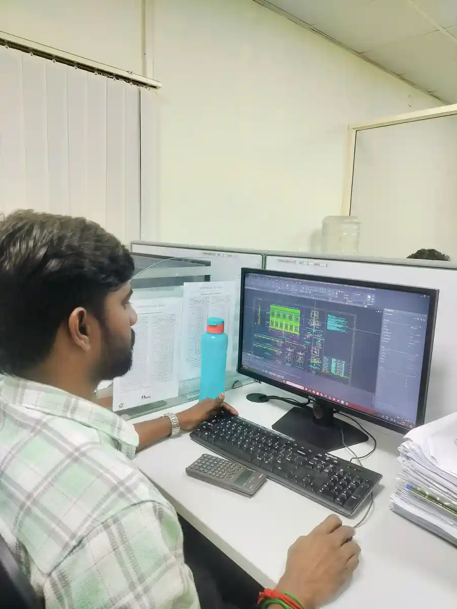 A software developer working on customized tools and management systems at an office workstation.