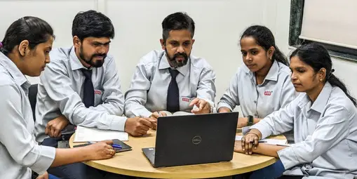 Corporate engineers sitting around a table for a technical training session.