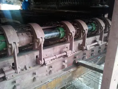 Mechanical drive system and rollers for a travelling grate stoker.